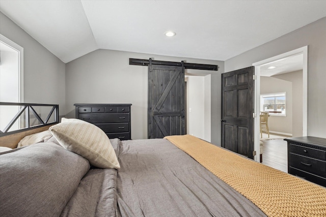 bedroom with lofted ceiling and a barn door