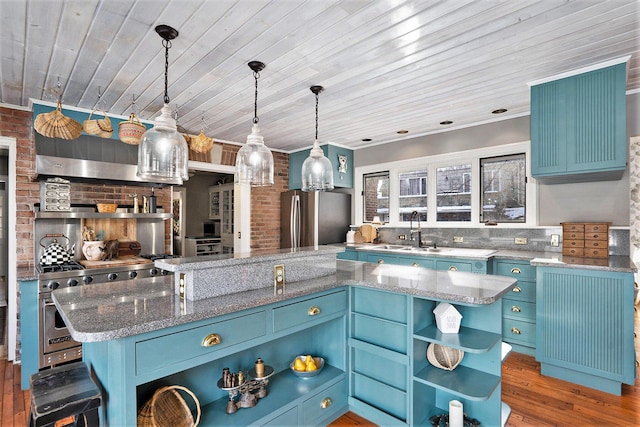 kitchen featuring decorative light fixtures, sink, a center island, stainless steel appliances, and blue cabinetry