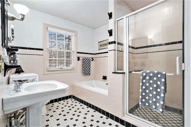 bathroom with shower with separate bathtub, tile walls, and tile patterned floors