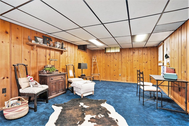 sitting room with dark colored carpet and a paneled ceiling