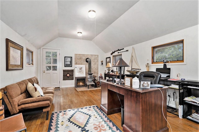 office featuring lofted ceiling and light hardwood / wood-style flooring