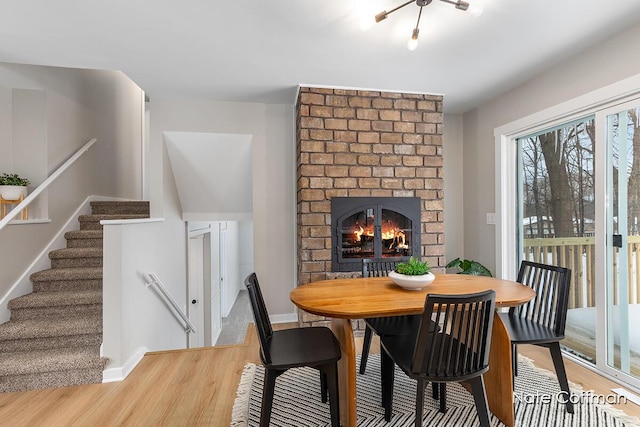 dining area featuring hardwood / wood-style flooring and a fireplace