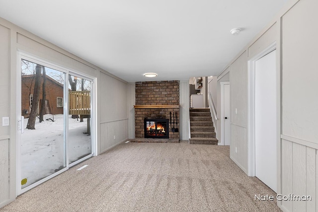 unfurnished living room featuring a fireplace and light colored carpet