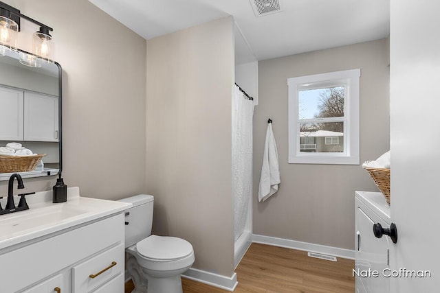 bathroom featuring washing machine and clothes dryer, vanity, toilet, and wood-type flooring