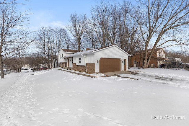 snow covered property featuring a garage