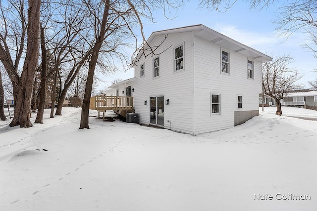 view of snow covered exterior featuring a deck and central air condition unit