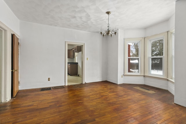 unfurnished room with dark hardwood / wood-style floors and a notable chandelier