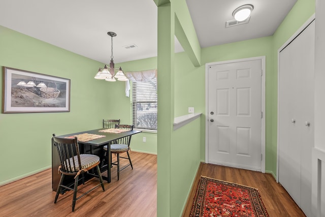 dining room with wood-type flooring and a chandelier