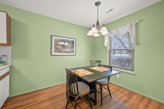 dining room featuring hardwood / wood-style floors and a notable chandelier