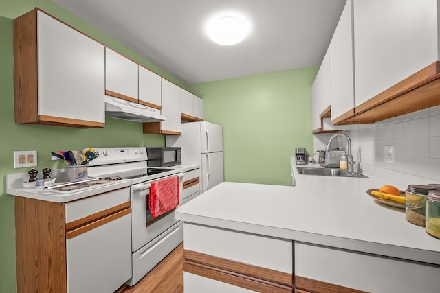 kitchen featuring tasteful backsplash, sink, white cabinets, and white appliances