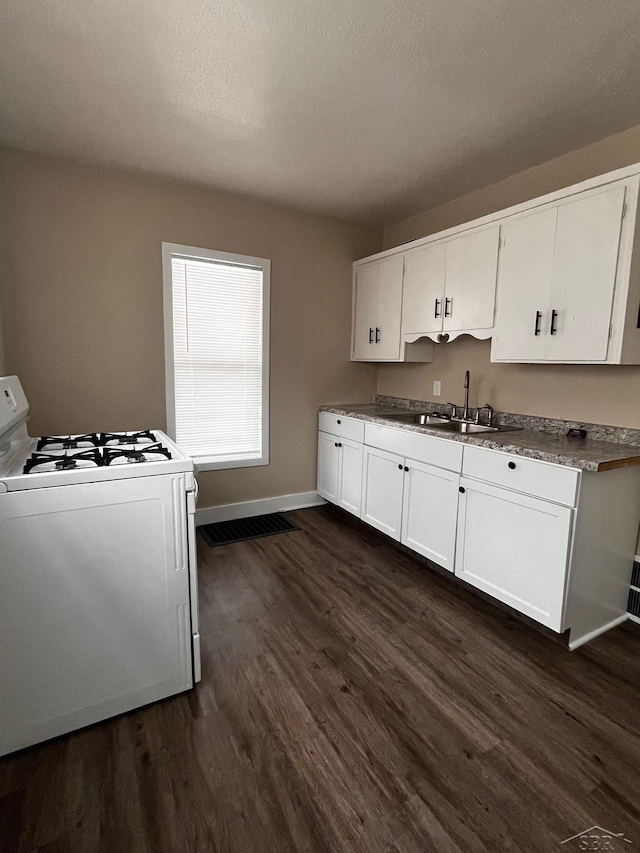 kitchen with white range with gas cooktop, sink, white cabinets, and dark hardwood / wood-style flooring