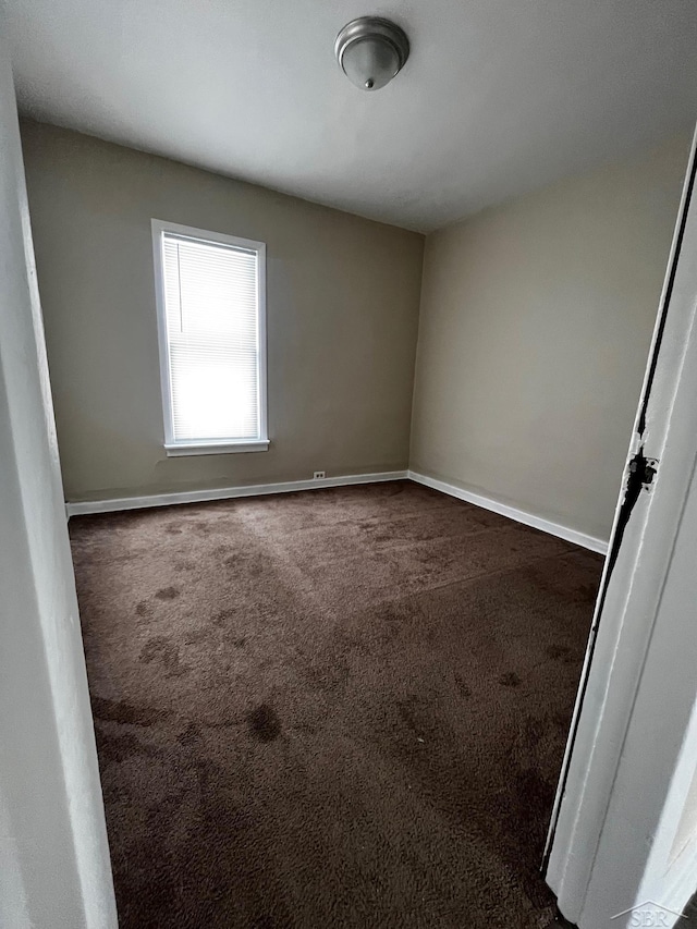 empty room featuring dark carpet