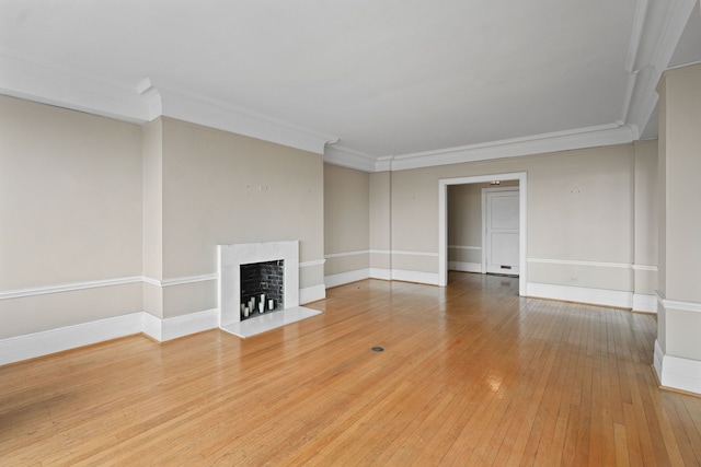 unfurnished living room with hardwood / wood-style flooring and crown molding