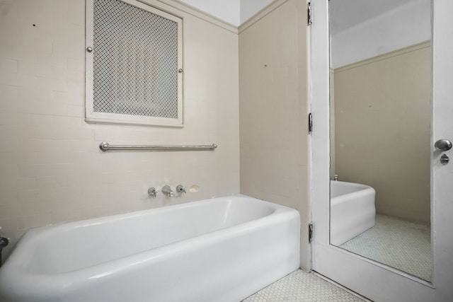 bathroom with a tub to relax in and tile patterned floors