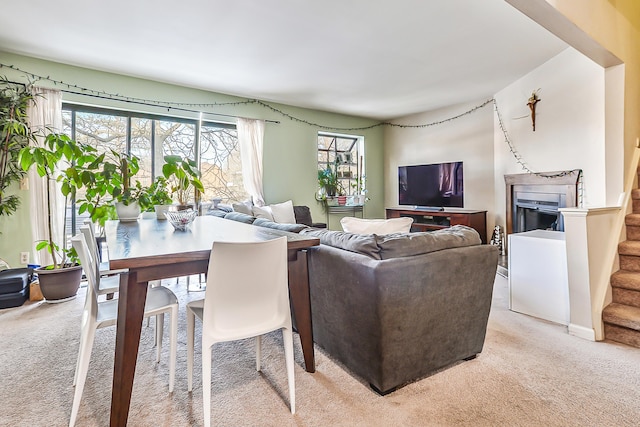 living area featuring stairs and light colored carpet