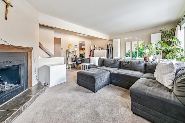 living area featuring carpet floors and a fireplace with raised hearth