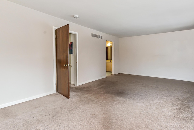 carpeted empty room with visible vents and baseboards