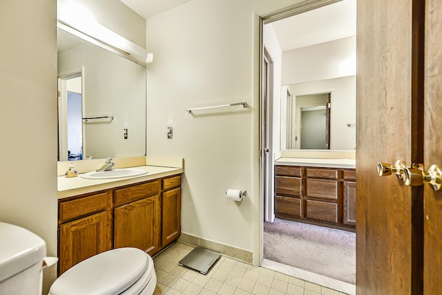 bathroom featuring baseboards, vanity, and toilet