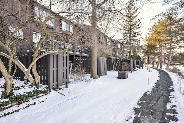 snowy yard featuring fence