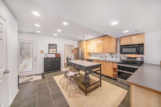 kitchen featuring appliances with stainless steel finishes, sink, light brown cabinets, and independent washer and dryer