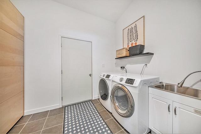 washroom with cabinets, washer and clothes dryer, sink, and dark tile patterned flooring