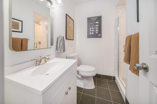 bathroom featuring tile patterned floors, toilet, a shower with shower door, and vanity