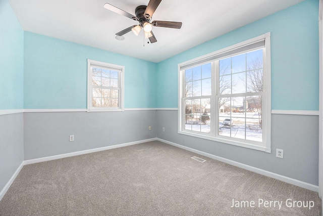 spare room with ceiling fan and carpet