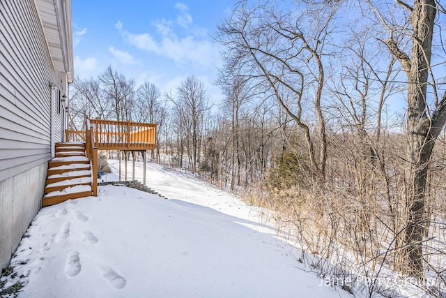 snowy yard featuring a wooden deck