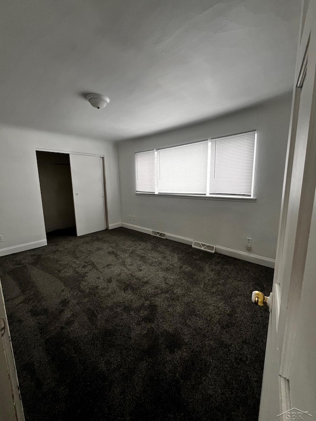 empty room featuring dark carpet