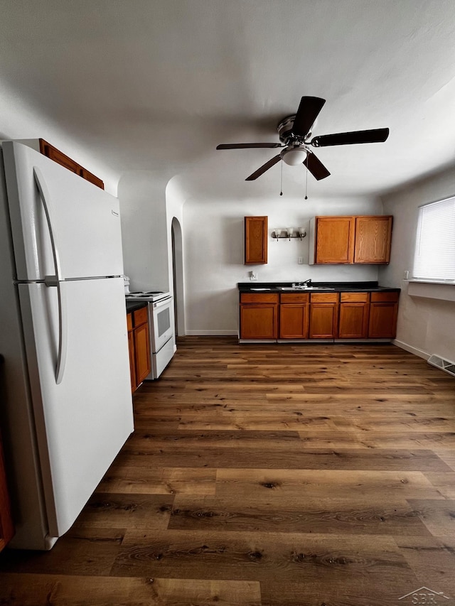 kitchen with ceiling fan, white appliances, and dark hardwood / wood-style flooring