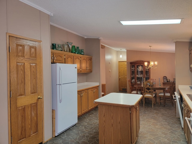 kitchen with a kitchen island, hanging light fixtures, white fridge, and a textured ceiling