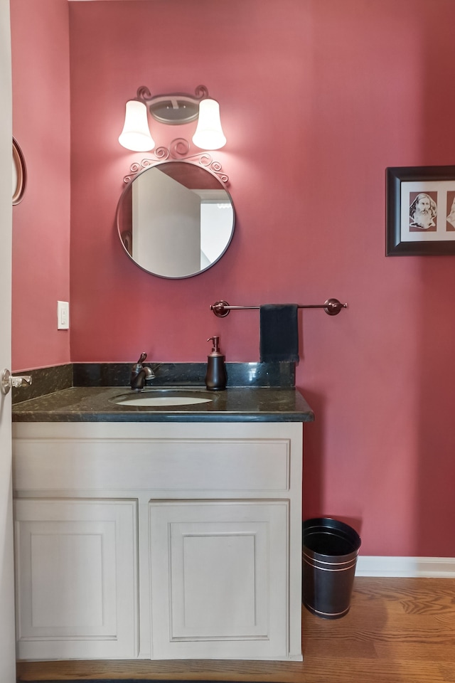 bathroom featuring vanity, baseboards, and wood finished floors