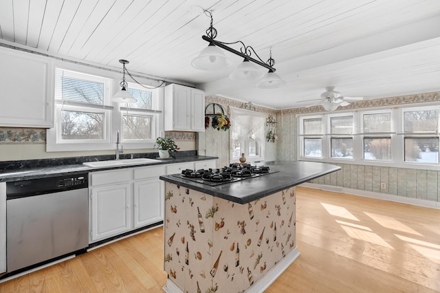 kitchen with sink, stainless steel appliances, light hardwood / wood-style floors, white cabinets, and a kitchen island