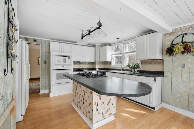 kitchen featuring sink, white cabinetry, decorative light fixtures, light wood-type flooring, and white appliances