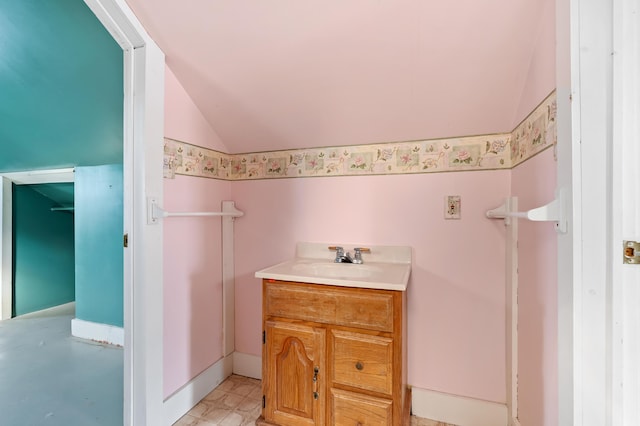 bathroom featuring vanity and lofted ceiling