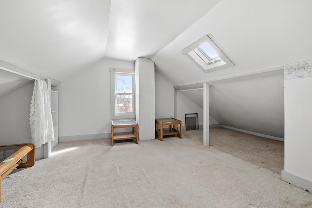 additional living space with lofted ceiling with skylight and light carpet