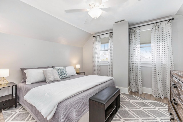 bedroom with hardwood / wood-style floors, vaulted ceiling, and ceiling fan