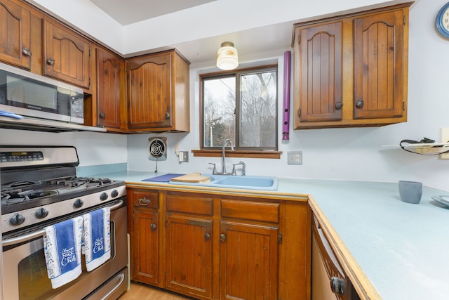 kitchen featuring a sink, visible vents, light countertops, appliances with stainless steel finishes, and brown cabinetry