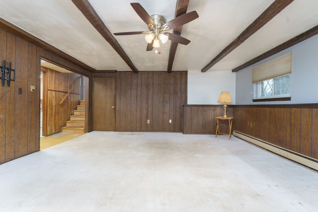 interior space with wood walls, stairway, a baseboard heating unit, and beam ceiling