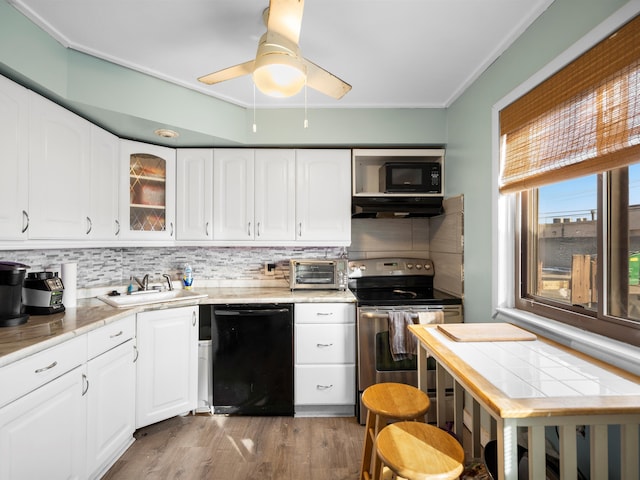 kitchen featuring sink, hardwood / wood-style flooring, black appliances, and white cabinets