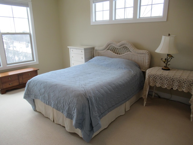 bedroom featuring light carpet and multiple windows