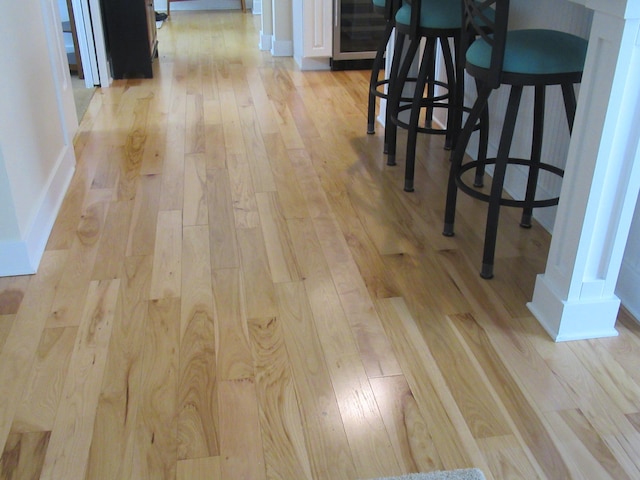 interior space with arched walkways, wood finished floors, and baseboards