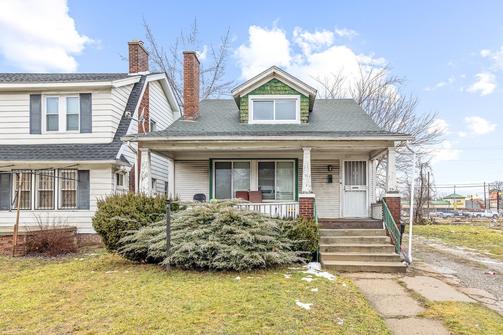 view of front of home with covered porch and a front yard