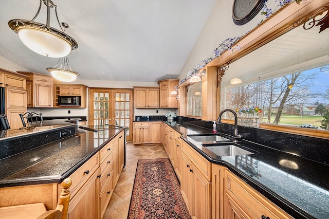 kitchen featuring lofted ceiling, sink, hanging light fixtures, and dark stone counters