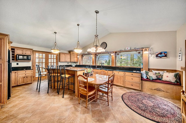 dining space with vaulted ceiling, sink, and a textured ceiling