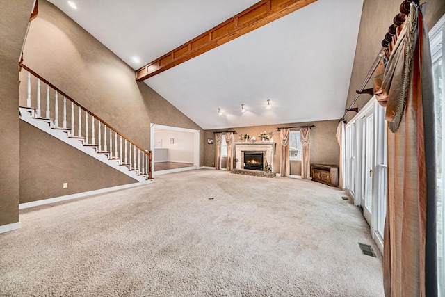 unfurnished living room with a brick fireplace, carpet floors, high vaulted ceiling, and beam ceiling