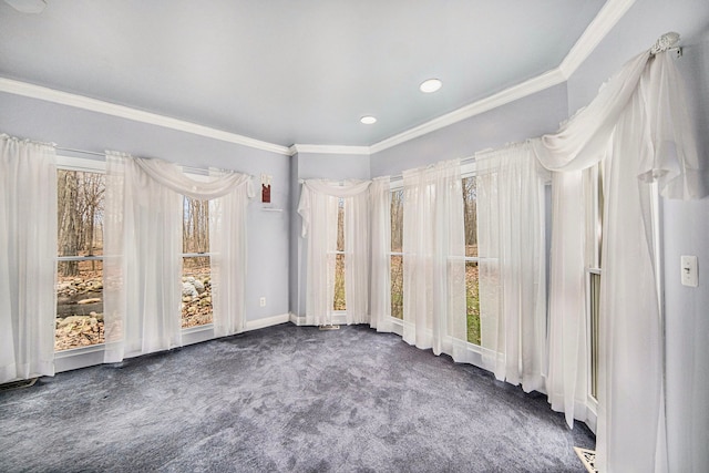 empty room featuring ornamental molding and dark carpet