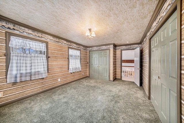 unfurnished bedroom with crown molding, carpet, two closets, and a textured ceiling