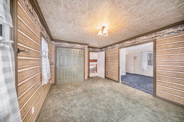 unfurnished bedroom with crown molding, carpet flooring, a textured ceiling, and a closet