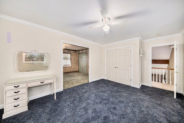 unfurnished bedroom with dark colored carpet, ceiling fan, crown molding, and a closet